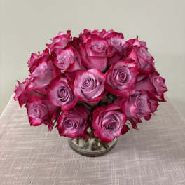 Bouquet of pink and lavender roses in a clear glass vase