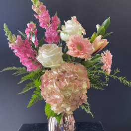 Arrangement of pink and white flowers with hydrangea and roses in a metallic rose-gold vase