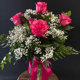 Pink roses with white baby's breath in a glass vase