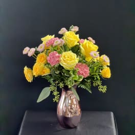 Yellow and pink roses with small pink daisies in a metallic vase