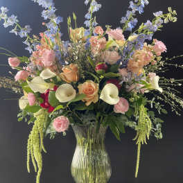 Large pastel floral arrangement in a clear glass vase