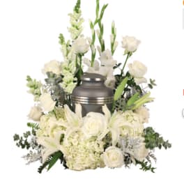 White floral funeral arrangement with a silver urn centerpiece