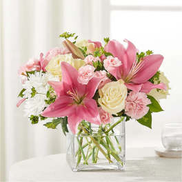 Pink lilies and roses in a clear glass vase