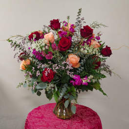 Mixed bouquet of red and peach roses in a glass vase