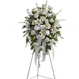 White floral standing spray on an easel with ribbon