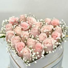 Heart-shaped box of pale pink roses with white baby's breath