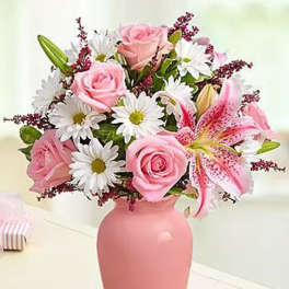 Pink roses and lilies in a pink vase with white daisies