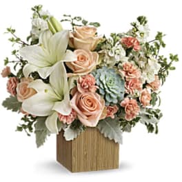 Peach roses and white lilies in a wooden cube vase