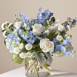 Blue and white flower arrangement in a clear glass vase