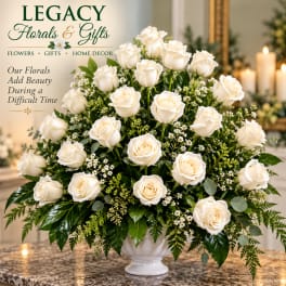 White rose arrangement in a white vase with greenery