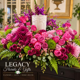 Pink roses and purple mums arranged in a white vase with greenery
