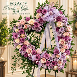 Heart-shaped rose wreath on an easel with a lavender ribbon
