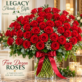 Large bouquet of red roses in a glass vase with a red ribbon