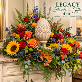 Large mixed floral arrangement with sunflowers, roses, and an urn centerpiece