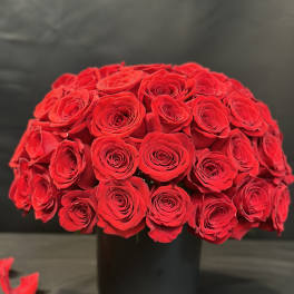 Round bouquet of red roses in a black vase
