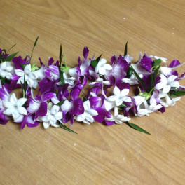 Purple and white flower garland laid on a wooden surface
