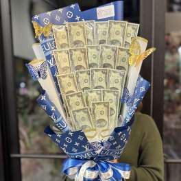 Bouquet of dollar bills wrapped in blue designer-pattern paper with ribbon
