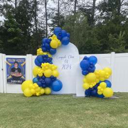 Blue and yellow balloon display around a graduation sign