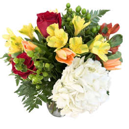 Mixed bouquet with red roses, yellow alstroemeria, and white hydrangea in a vase