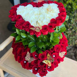 Heart-shaped arrangement of red and white roses with butterfly accents
