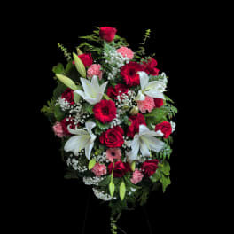 Standing floral spray with red roses, white lilies, and pink carnations
