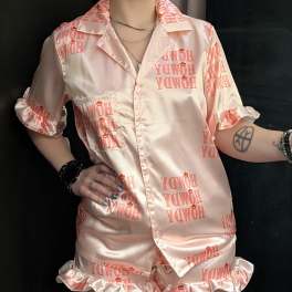 Person wearing pink satin pajama set with "Howdy" print