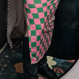 Pink and green checkered fabric draped over a dark object