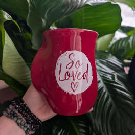 Red memorial candle holder with "So Loved" text