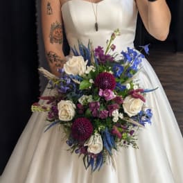 Bride holding a bouquet of white, blue, and purple flowers