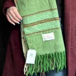 Person holding a green striped scarf with fringe