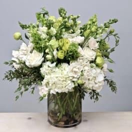 White and green floral arrangement in a glass vase