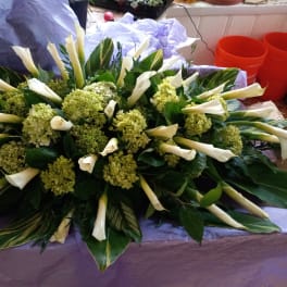Large white calla lily and green hydrangea arrangement on a table
