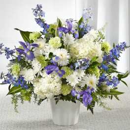 White and purple floral arrangement in a white vase