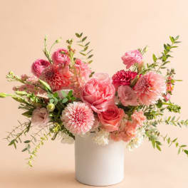 Pink and peach flower arrangement in a white vase
