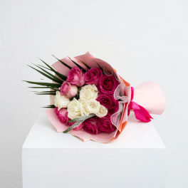 Bouquet of pink and white roses wrapped in pink paper