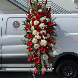 Tall red and white floral standing spray on an easel
