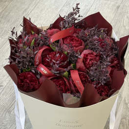 Bouquet of deep red flowers in a cream gift box