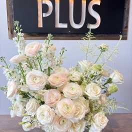 Cream and blush bouquet of roses and ranunculus on a table