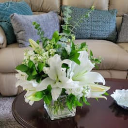 White lilies arranged in a clear glass vase