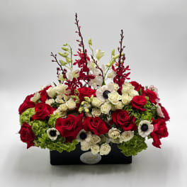 Red and white roses arranged in a black rectangular container