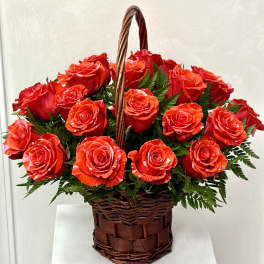 Basket of red roses with greenery