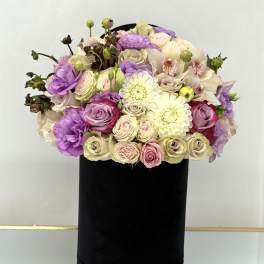 Bouquet of pastel roses, orchids, and white dahlias in a black box