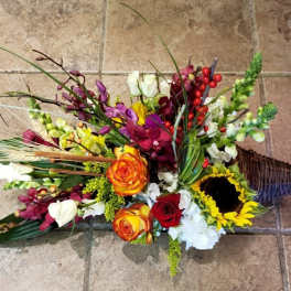 Colorful floral arrangement in a wicker cone basket with sunflowers and roses