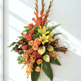 Tall floral arrangement with orange roses and yellow lilies