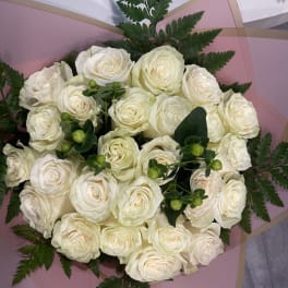 Bouquet of white roses wrapped in pink paper