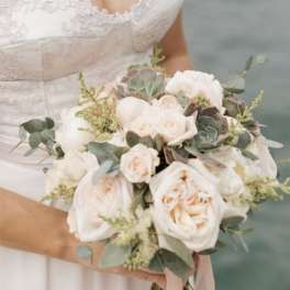 Bride holding a white and blush bouquet with greenery
