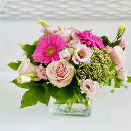 Pink roses and gerbera daisies in a clear glass vase