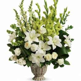 Tall white and green arrangement with lilies, roses, and carnations in an ornate ceramic urn.