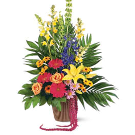 Tropical mixed flower arrangement in a brown basket with bright blooms