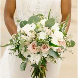 Bride holding a white and blush bouquet with greenery